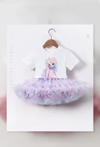 Détail du t-shirt blanc imprimé licorne avec une jupe tutu multicouche rose et violette