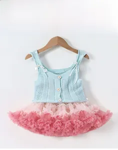 Dettaglio gilet in maglia bambina con bottoni in legno e gonna tutu rosa