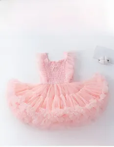 Détail d'une robe en tulle rose pour fille avec corsage plissé et nœuds en perles