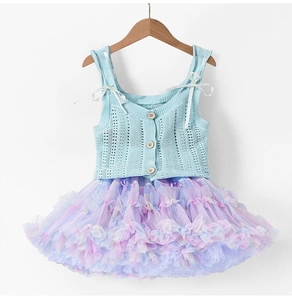Dettaglio del gilet in maglia per bambine con bottoni in legno e gonna tutu colorata