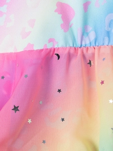 Détail macro du tissu dégradé arc-en-ciel avec paillettes étoiles et lunes sur tulle