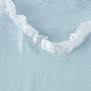 Détail du tissu en maille côtelée bleu clair avec bordure en dentelle blanche sur le haut