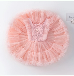 Détail de la robe rose en dentelle avec corsage plissé et nœud en perles sur tulle