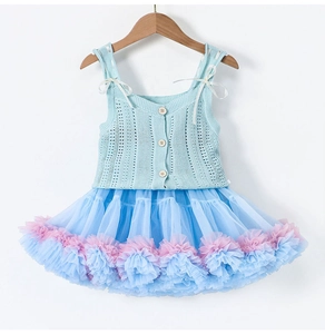 Dettaglio abito in maglia per bambina con bottoni in legno e gonna tutu in tulle blu