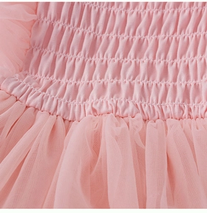 Détail d'une robe rose pour fille montrant le corsage froncé et les couches de tulle