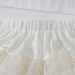 Détail de jupe tutu en tulle blanc avec taille élastique et délicat nœud en soie
