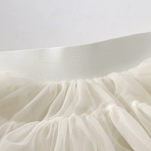 Detail of white tiered tulle skirt showing elastic waistband and fine mesh pleats