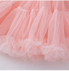 Détail d'une jupe en tulle rose à plusieurs couches avec dentelle plissée fine