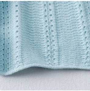Dettaglio del tessuto a maglia traforata azzurro con motivi pointelle per set estivo