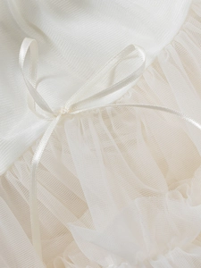 Détail d'une jupe tutu blanche élégante montrant le tulle multicouche et le nœud en satin