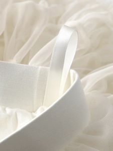 Detailed close-up of white mesh tutu skirt waist with elastic band and satin hanging loops