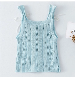Dettaglio del gilet in maglia azzurro con righe traforate e fiocco di nastro bianco