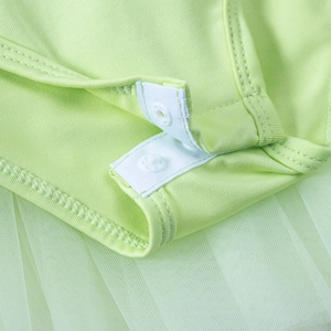 Close-up of snap fasteners and mesh trim on a light green girls' ballet tutu bodysuit