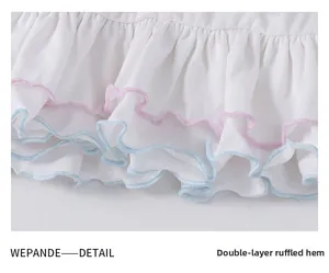 Détail de l'ourlet du tutu blanc avec des bords volantés roses et bleus pour filles