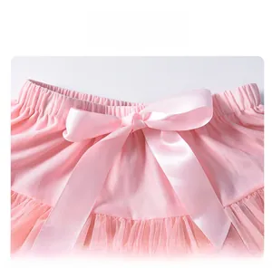 Close-up of pink tutu skirt featuring elastic waistband and satin bow detail