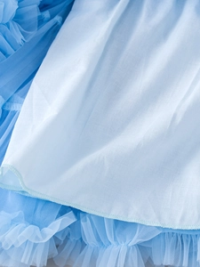 Detailed close-up of sky blue mesh tutu layers and smooth fabric ruffles on the dress