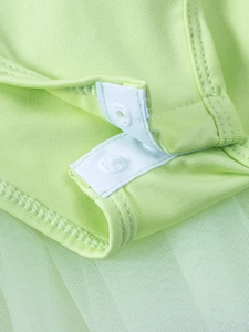 Detail of light green tutu dress showing snap button closure and soft mesh fabric