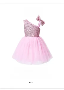 Detail of pink tutu dress featuring sequined bow strap and layered mesh fabric