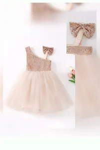 Detail of sequined bodice and large shoulder bow on pink tulle flower girl dress