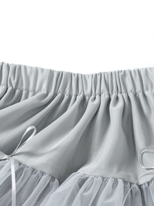 Détail de la taille élastique avec nœud et tulle blanc sur une jupe tutu grise