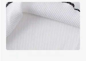 Macro detail of white ribbed knit fabric with soft texture and durable black overlock stitching