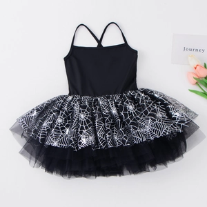 Detail view of black girls tutu dress featuring silver spider web print and crisscross straps