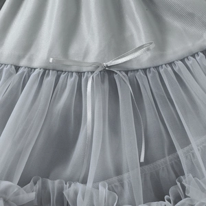 Détail d'une jupe en tulle multicouche avec nœud décoratif en satin et volants fins