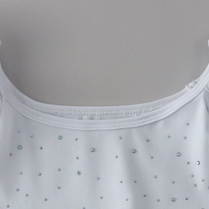 Détail de l'encolure en coton blanc avec de délicats motifs d'étoiles en strass brillant