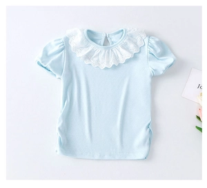 Détail d'un t-shirt bébé bleu clair en coton avec col en dentelle et tissu respirant
