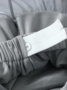 Détail de la taille élastique ajustable avec bouton sur une jupe tutu grise