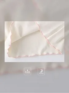 Detailed macro view of girls' top showing pink ruffled edges and combed cotton texture