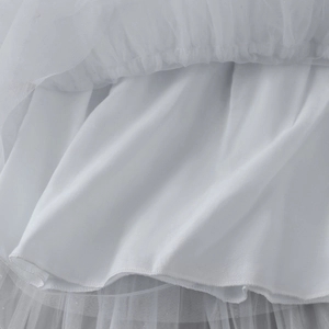 Détail du tissu en tulle blanc multicouche et de l'ourlet de la robe gâteau pour fille