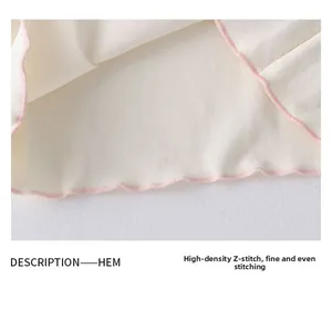 Close-up of high-density zigzag stitching and pink hem detail on girls' knit top