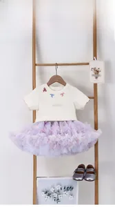 Detail of girls' cream t-shirt with bow embroidery and purple layered tutu skirt set