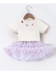 Close-up of rainbow tutu skirt and white t-shirt with delicate bow embroidery detail