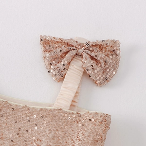 Detailed view of champagne sequin bow on kid girl dress shoulder strap