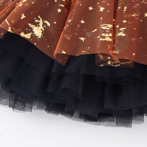 Detail view of double-layered orange and black tutu skirt with gold foil star print