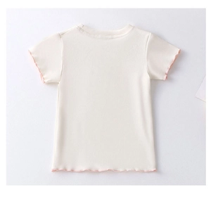 Detailed view of baby girl white cotton T-shirt with pink ruffled hems and soft fabric