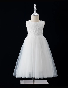 Dettaglio di ricami floreali 3D e paillettes su abito da cerimonia in tulle bianco bimba