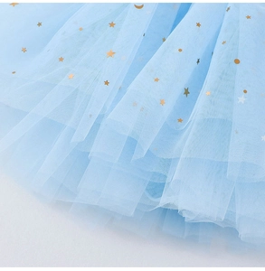 Détail d'une jupe en tulle bleu clair avec étoiles et lunes dorées pour filles