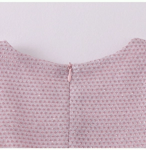 Close-up of pink glitter fabric and invisible zipper on the back of a girl's dress