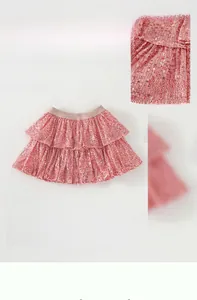 Detailed close-up of pink sequined tutu skirt featuring a tiered ruffle cake design