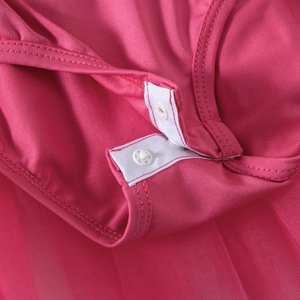 Detail view of pink ballet dress featuring snap button closure at the crotch area