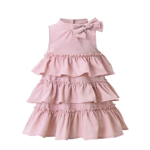 Detail of light pink sleeveless girls' dress with bow neckline and tiered ruffle hem