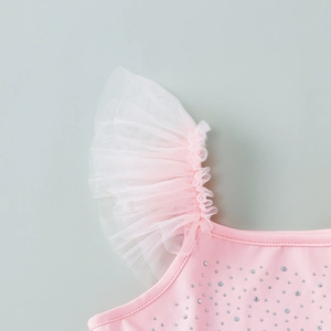Detail of pink dance bodysuit featuring ruffled lace sleeves and sparkling rhinestones