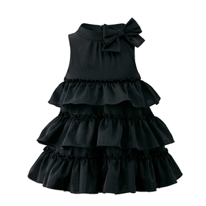 Detail of black sleeveless layered chiffon cake dress with large bow accent