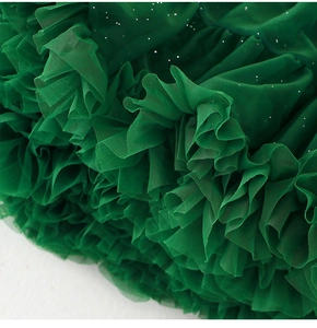 Détail de la jupe tutu en tulle vert foncé avec paillettes et texture de maille à volants