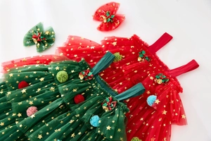 Detailed view of red and green Christmas tutu dresses with gold stars and festive bows