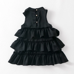 Detail of child black tiered cake dress featuring three elegant pearl buttons on the back