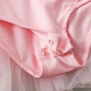 Close-up of double resin snaps and mesh skirt stitching on pink girls ballet leotard